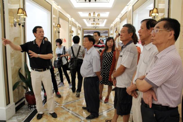 图3、918博天堂市场总监霍达炎（左一）在为旅行者先容釉面砖展示空间.jpg